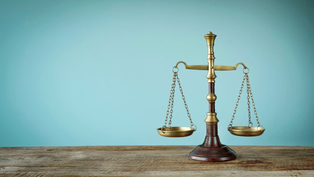 Scales of justice on the wooden table